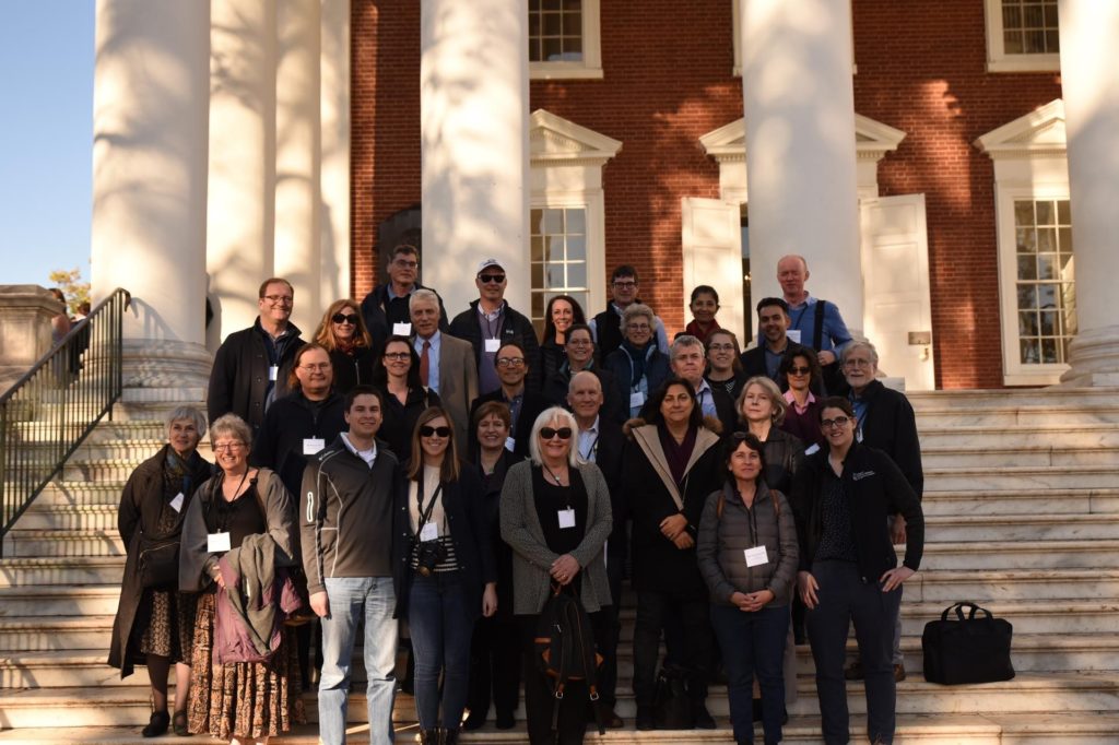 A large group of people who attended the 2019 Symposium. They are standing in front of one of the historic buildings at UVA.