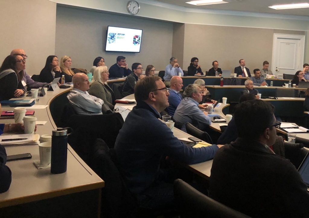 Many people sitting at tables listening at a conference